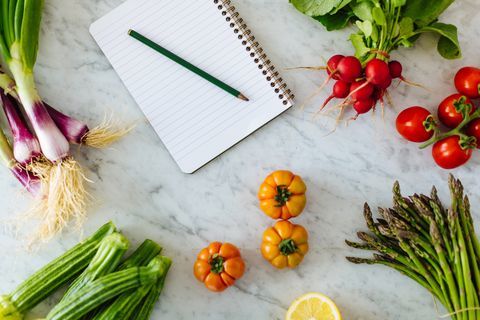 Ylhäältä notepad ja kynä tuoreita vihanneksia