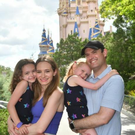 perhe hymyilee Cinderella linnan edessä Magic Kingdom Parkissa